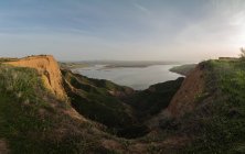 Величний краєвид на порослий травою каньйон і спокійне озеро, що здіймається над ранковим небом у сільській місцевості в Барранкас - Буружон (Толедо, Іспанія). — стокове фото