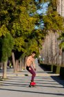 Corpo inteiro jovem hispânico homem com mochila andar de skate na calçada no dia ensolarado na rua da cidade — Fotografia de Stock
