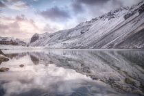 Calm lake and snowy mountain on cloudy sundown sky in Swiss National Park in Switzerland — Stock Photo