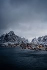 From above of city harbor against snowy mountain ridges at horizon in overcast weather in Norway — Stock Photo