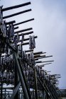 Снизу конструкция с металлическими колоннами и балками с повешенной сухой рыбой против серого облачного неба на улице в Норвегии — стоковое фото