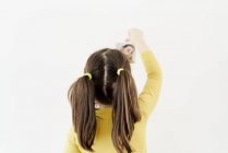 Мила дівчинка в жовтій сукні стоїть на спині, розміщуючи фотографії себе, демонструючи різні емоції — стокове фото
