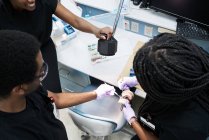 Colegas negros examinando prótesis en laboratorio - foto de stock