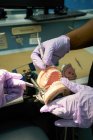 Collèges noirs examinant la prothèse dentaire en laboratoire — Photo de stock