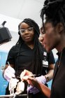 Colegas negros examinando prótesis en laboratorio - foto de stock