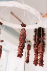 From below pieces of delicious dried meat hanging on ropes from ceiling in cozy local food store — Stock Photo