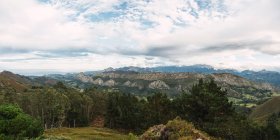 Verde valle escena con montañas y cielo nublado - foto de stock
