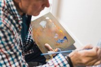 Uomo anziano quadro pittura con pennello — Foto stock