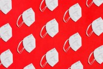 Collage de algunas máscaras blancas para el factor de protección KN95 sobre fondo rojo cenit view - foto de stock