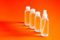 Кілька прозорих пляшок з соляним гелем разом з воронкою для заповнення служить для дезінфекції вигляду рук ковіда-19 — стокове фото