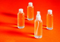 Diverse bottiglie trasparenti con gel cloridrico insieme a un imbuto da riempire serve a disinfettare la vista dall'alto delle mani di covid-19 — Foto stock