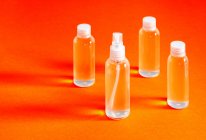 Викривлений вид зверху різних прозорих пляшок з соляним гелем для наповнення служить для дезінфекції рук ковіда-19 — стокове фото