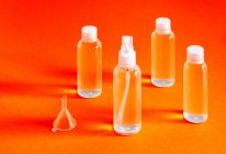 Misaligned top view of various clear bottles with hydrochloric gel for filling serves to disinfect the hands of covid-19 — Stock Photo