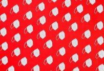 Colagem de muitas máscaras de proteção de fator KN95 em uma visão aérea de fundo vermelho na distribuição diagonal — Fotografia de Stock