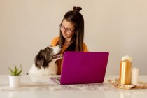 Cheerful woman playing with dog at home — Stock Photo