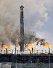 Выветриваемые промышленные здания и трубы, излучающие дым и пламя на коксохимическом заводе — стоковое фото