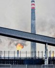 Погодні промислові будівлі і труби, що випускають дим і полум'я на коксохімічному заводі — стокове фото