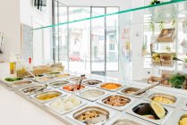 Modernes Restaurant mit Selbstbedienungssystem und serviert köstliche Speisen und Gerichte in warmen Metallbehältern auf der Theke — Stockfoto