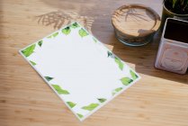 Vista dall'alto del menù carta laminata composta su tavolo in legno vicino al vaso da fiori e vari oggetti in legno e metallo — Foto stock