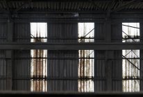 Shabby vecchio muro di metallo ruggine con punti salienti di luce penetrante da finestre opposte che si trovano all'interno di un edificio abbandonato fabbrica deserta in Spagna — Foto stock