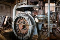 Ancien équipement industriel gris ralenti de générateur d'énergie avec divers fils tuyaux en acier et boulons dans la mine de charbon abandonnée déserte — Photo de stock