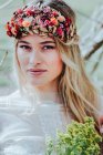 Junge Braut mit Kranz und Blumen — Stockfoto