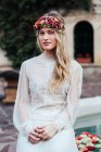 Junge Braut mit Kranz und Blumen — Stockfoto