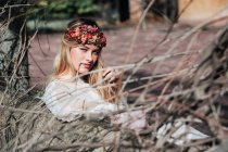 Young bride sitting on bench in garden — Stock Photo