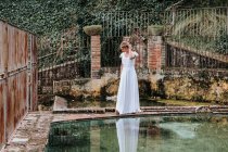 Jeune mariée près d'une clôture et d'une piscine minables — Photo de stock