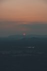 De cima da visão majestosa de sol e silhuetas de picos de montanha durante o pôr-do-sol em Sigiriya — Fotografia de Stock