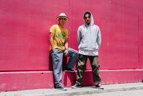 Due giovani ballerini urbani in piedi vicino a un muro rosa sulla strada — Foto stock