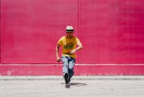 Молоді іспаномовні чоловіки танцюють біля рожевої стіни на вулиці — стокове фото