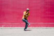 Jovens hispânicos dançando perto de uma parede rosa na rua — Fotografia de Stock