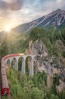 Train sur chemin de fer sur pont voûté dans la scène montagneuse verte, Suisse — Photo de stock