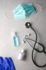 Gel antibatterico, maschera medica e stetoscopio sul tavolo — Foto stock