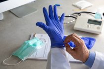 Male doctor putting on surgical gloves, cropped shot — Stock Photo
