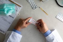 Medico maschio mani tenendo confezione di pillole — Foto stock