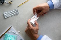 Чоловічі руки лікаря тримають упаковку таблеток — стокове фото