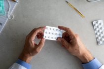 Homme médecin mains tenant paquet de pilules — Photo de stock