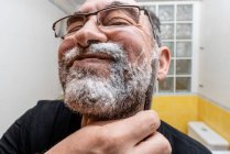 Hombre barbudo afeitándose con navaja de afeitar recta - foto de stock