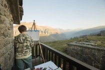 Anonymer Junge malte auf Staffelei auf sonniger Terrasse in der Landschaft Spaniens — Stockfoto