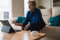 Vieja mujer comunicarse con su hija en el chat de vídeo en el ordenador portátil - foto de stock