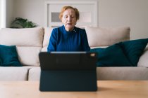Стара жінка спілкується з дочкою на відео чаті на ноутбуці — стокове фото