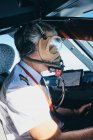 Пилот в маске, управляющий самолетом во время полета — стоковое фото