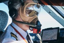 Piloto em máscara operando avião durante o voo — Fotografia de Stock