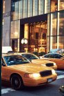 Modern yellow taxi cars driving on paved street in central district of New York city — Stock Photo