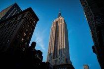 Torre no centro da cidade de Nova York contra o céu azul à luz do sol — Fotografia de Stock