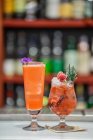 Two berry cocktails with ice and fresh herbs at bar counter — Stock Photo