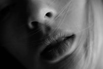 Primo piano raccolto giovane donna con labbra sensuali e capelli biondi che ondeggiano sul viso — Foto stock