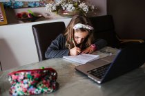 Mädchen erledigt Hausaufgaben vom Laptop aus — Stockfoto